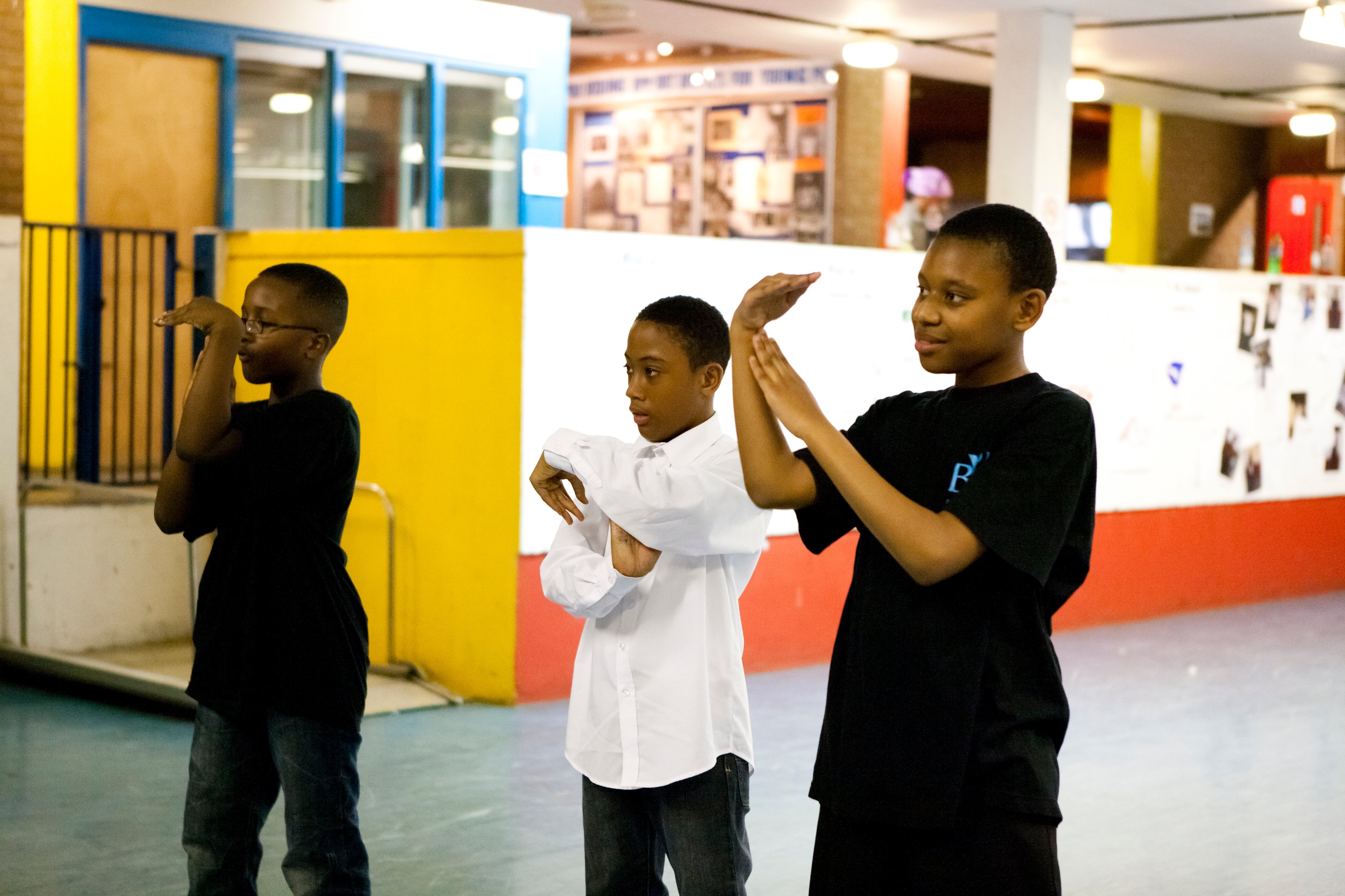 Three boys dancing with arms