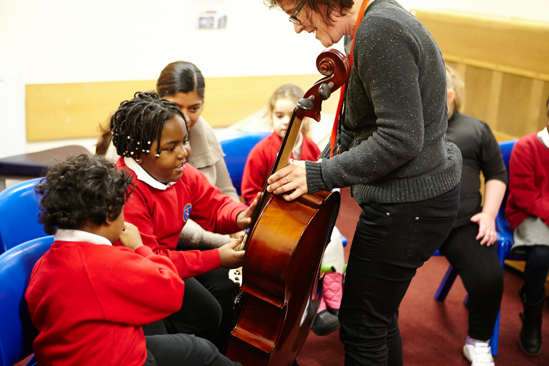 Children looking at a cello